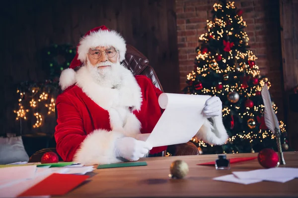 照片上喜庆积极的圣诞老人身穿红色服装读着新年贺信回家北极 — 图库照片