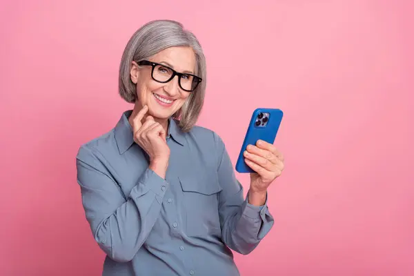 stock image Photo of cheerful satisfied retired lady office manager hand touch face modern gadget wifi connection isolated on pink color background.