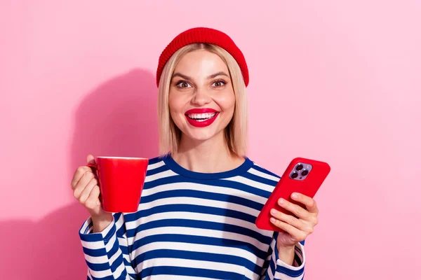 Photo of cool funky girl dressed striped shirt enjoying tea typing apple samsung iphone gadget isolated pink color background.