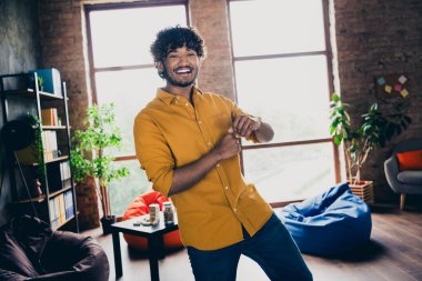 Photo portrait of attractive young man wear yellow shirt excited dancing have fun modern workplace room home design. clipart