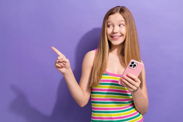 聪明快乐的少女穿着五颜六色的单色导演形象空空荡荡的太空智能手机手牵着紫色的背景 — 图库照片