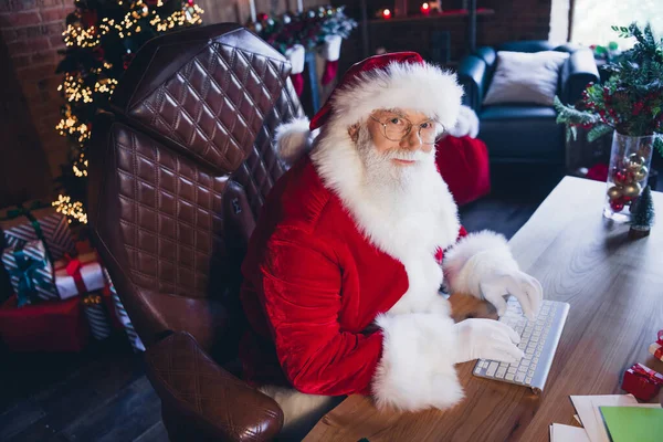 聪明忙碌的圣诞老人穿着红色服装在室内传达现代装置的照片 — 图库照片