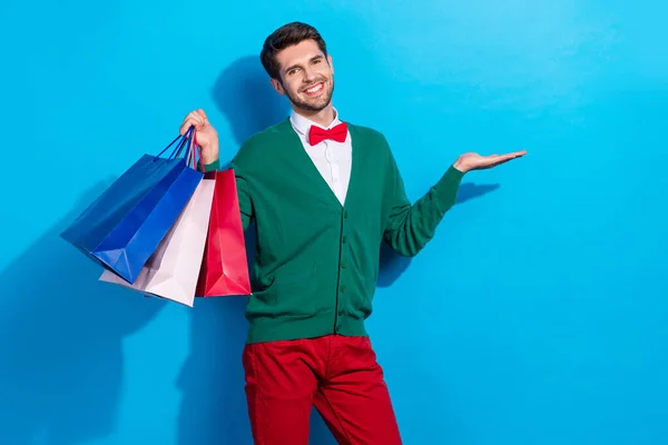 正の魅力的な男の写真は 青の色の背景に隔離されたカードオンラインNfc支払いを示す休日の購入を喜ぶ — ストック写真