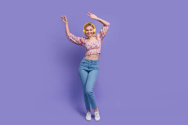 魅力的な陽気な女性の完全なボディ肖像画は紫色の背景で隔離された空のスペースを踊るお気に入りの曲ヘッドフォンを聞きます — ストック写真