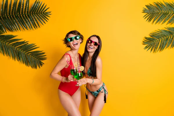 照片上穿着泳衣的女孩们穿着时髦的好心情 享受着酒精鸡尾酒空旷的空间 孤立的黄色背景 — 图库照片