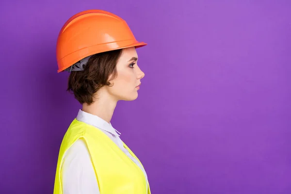 Profile photo of serious nice brunette hair lady look empty space wear builder uniform isolated on vivid purple color background.