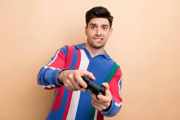 心配した若者の肖像画 唇の腕を噛む コントローラー ベージュ色の背景で隔離されたビデオゲーム — ストック写真
