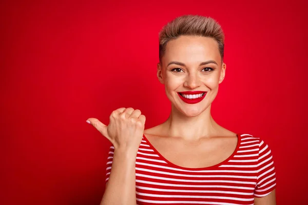 親指左の空きスペースを監督する若い女性プロモーターの肖像画 赤い色の背景で隔離されたモデル代理店広告に参加 — ストック写真