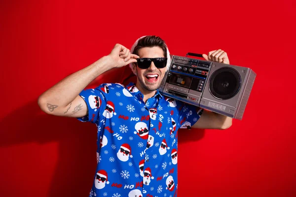 幸せな新年の懐かしいパーティーの写真 若い男のカセットプレーヤーのブームボックスは赤い色の背景で隔離された青いシャツとサングラスを着用します — ストック写真