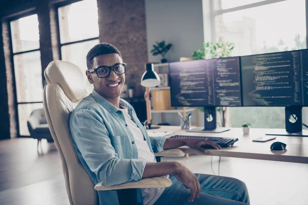 Portrait of young smiling guy sitting armchair smart senior devops professional programmer control cyber security at work place in office.