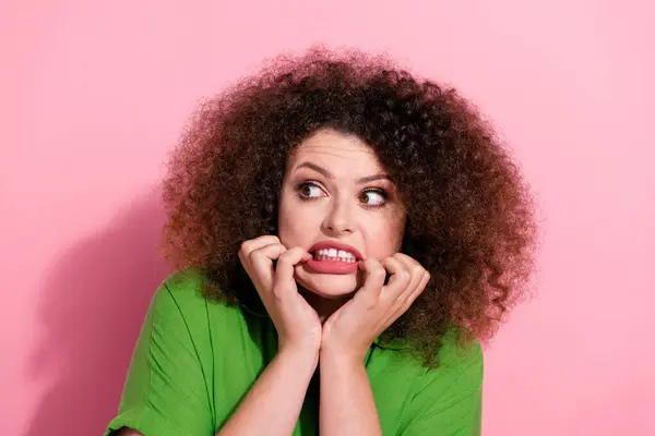 Photo of nervous terrified young woman dressed green shirt arms hands cheekbones looking empty space isolated pink color background.