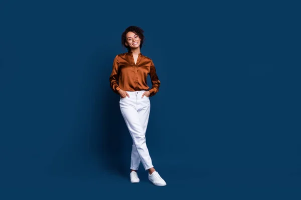 Full length photo of cute adorable woman dressed brown silk shirt walking empty space isolated blue color background.
