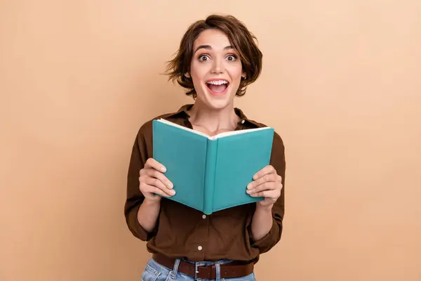 印象的なファンキーな女性の写真は茶色のシャツを着て良い本の開いた口の隔離されたベージュ色の背景を楽しんでいます — ストック写真