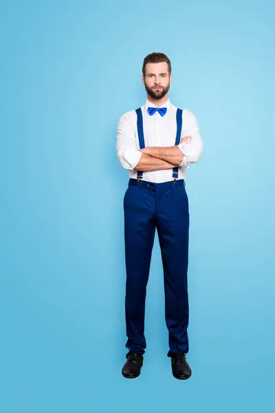 Full size full body portrait of famous talented singer in blue ourfit, wearing bow, white shirt, suspenders, isolated over grey background, holding arms crossed.