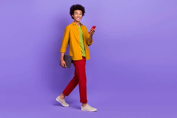 滑稽而快乐的男人穿着时髦的衣服散步聊天现代科技空旷的空间与紫色背景隔离的照片 — 图库照片