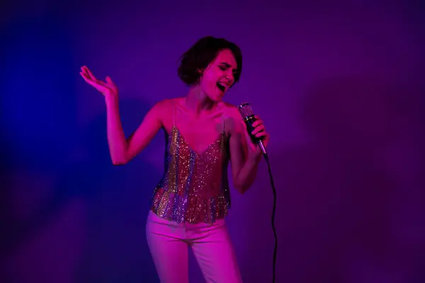 Photo of crazy lady pop star singing in nightclub stage on new year christmas isolated neon color background.