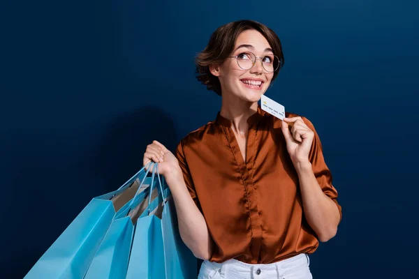 Photo of pretty girl look interested empty space credit card shopper dressed stylish brown blouse isolated on dark brown color background.