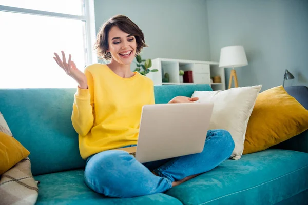 Photo of positive cheerful lady sitting couch using netbook have online lesson distant education indoors.