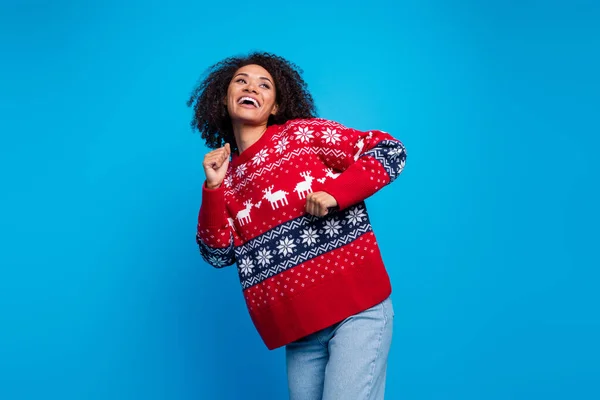Photo of crazy cheerful girl wear trendy ugly sweater looking empty space dancing winter event isolated on blue color background.
