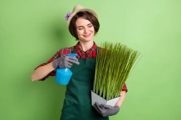 照片上乐观漂亮的棕色短发女士在绿色背景下与植物隔离的头戴帽子衬衫 — 图库照片