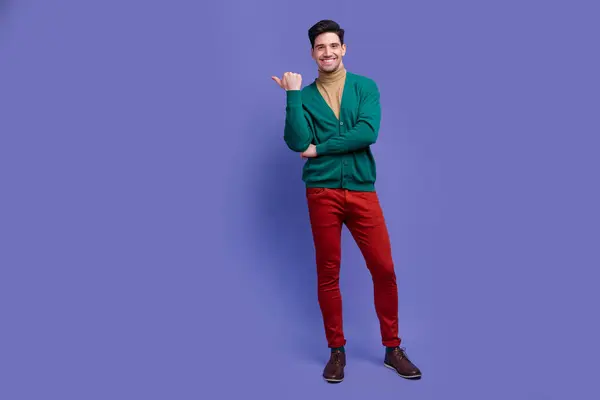 紫色の背景に隔離されたスタイリッシュな服コレクションブランドの空のスペースを提示する素敵な幸せな男の完全な長さの写真 — ストック写真