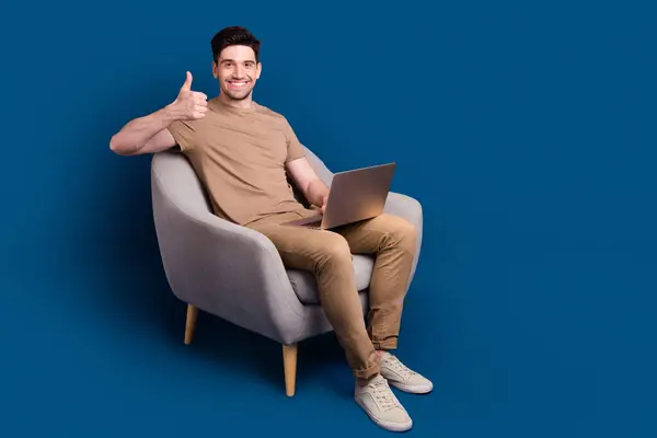 Portret Pogodnego Mężczyzny Ubranego Beżowy Shirt Siedzi Fotelu Laptopem Pokazuje — Zdjęcie stockowe
