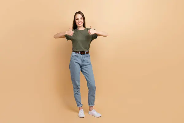 ベージュ色の背景に隔離されたサインアップカーキTシャツデニムジーンズを着用魅力的な成熟した幸せな女性のフルボディサイズの写真 — ストック写真