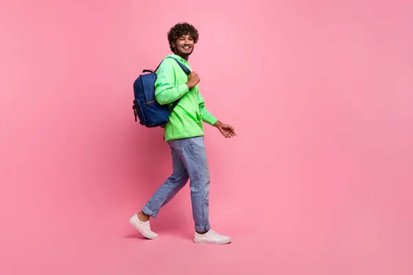 stock image Full body length photo of steps young hipster student indian man wear rucksack behind going to study isolated on pink color background.