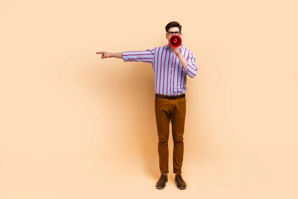 Photo of aggressive irritated man chief wear stylish clothes scream shout arm demonstrate empty space isolated on beige color background.