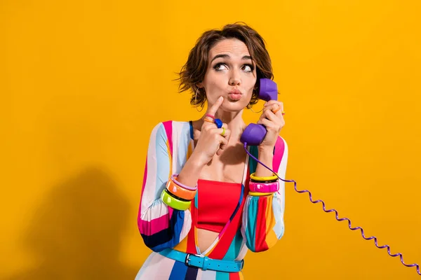 Photo of funky shocked woman dressed striped suit talking land line looking empty space isolated yellow color background.
