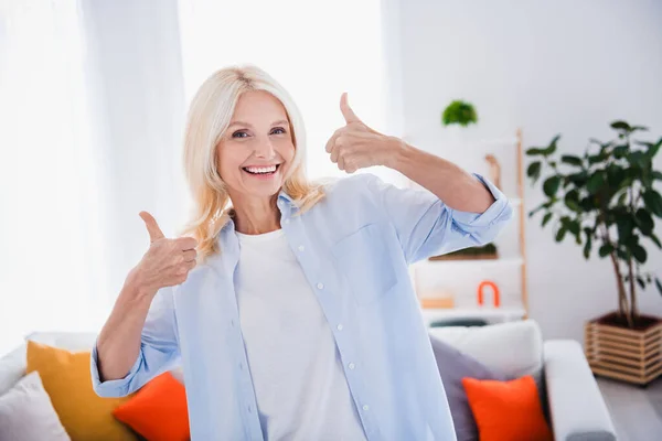 Portrait of nice feedback good job symbol mature aged businesswoman thumbs up likes her new office with living room interior indoors.