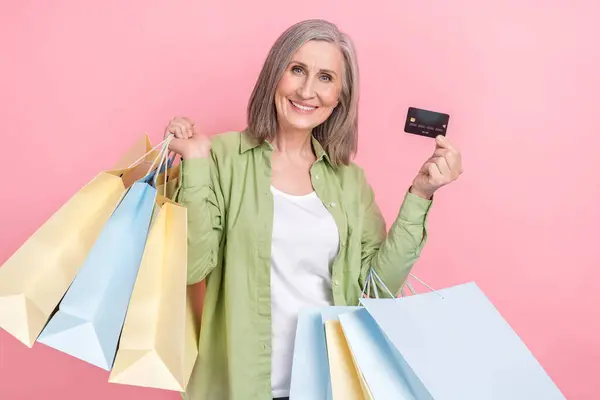 魅力的な灰色の白い髪の祖母の写真は 緑のスタイリッシュな服を着ています パッケージ ピンク色の背景に分離されたプラスチックカード — ストック写真