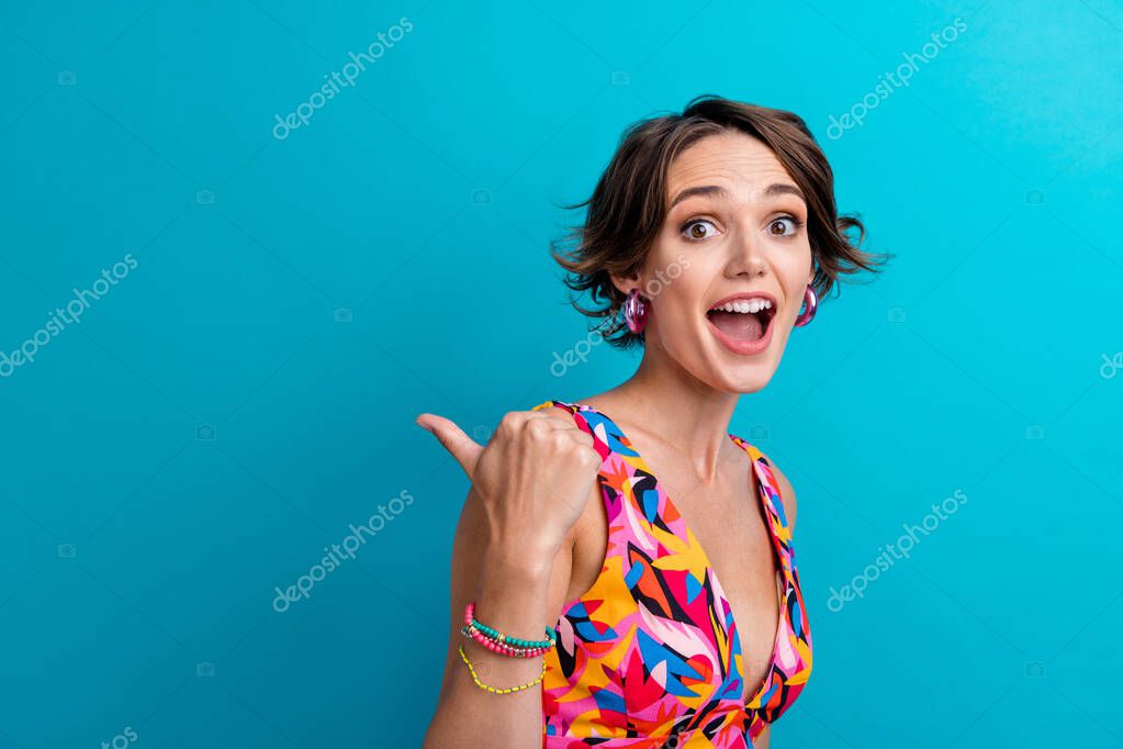 Photo of ecstatic woman with short hairstyle dressed colorful clothes indicating at discount empty space isolated on blue color background.