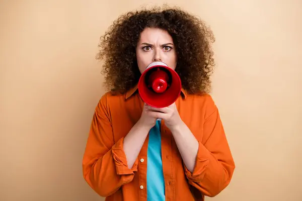 Photo of aggressive furious woman boss shouting holding bullhorn isolated on beige color background.