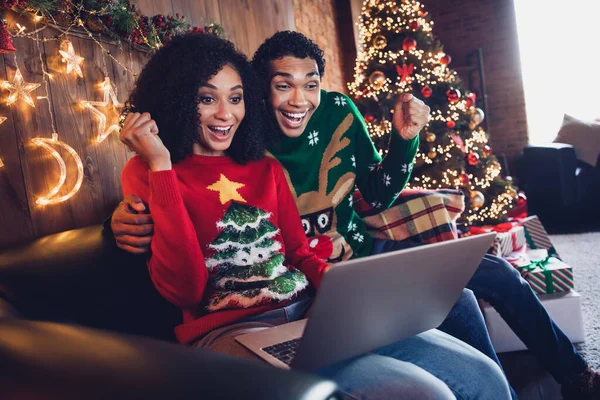Photo of excited people friends sit sofa in illuminated light house room browsing web netbook for incredible tradition x mas season discounts.