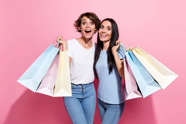 驚いた2人の若い女の子の写真は トルコのブランドがどのように価格割引プロモーションコード広告バッグをピンク色の背景に分離したかを驚かせました — ストック写真