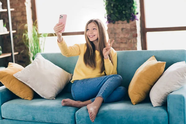 在网上学习时 十几岁女孩的照片向朋友们展示了自己坐在沙发上的手机摄像头 — 图库照片