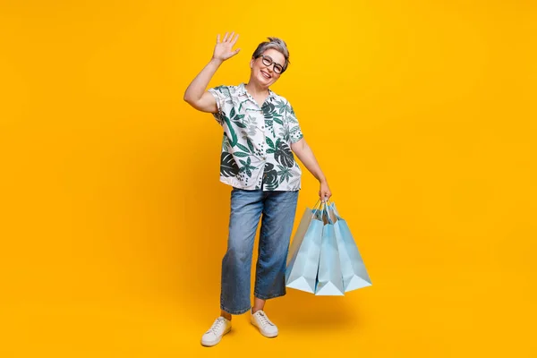 Çekici Yaşlı Kadın Alışveriş Çantalarının Tam Boy Fotoğrafı Sallıyor Sarı — Stok fotoğraf