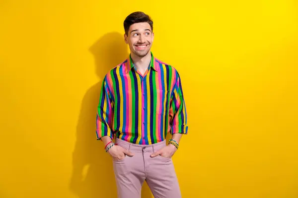 Portrait of young happy guy thinking looking empty space curious choosing new outfit for nightclub isolated on yellow color background.