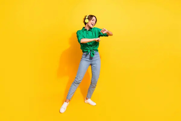 楽しい隔離された黄色の背景を持っている陽気な肯定的な女の子の完全な長さの写真緑のシャツのヘッドフォン — ストック写真