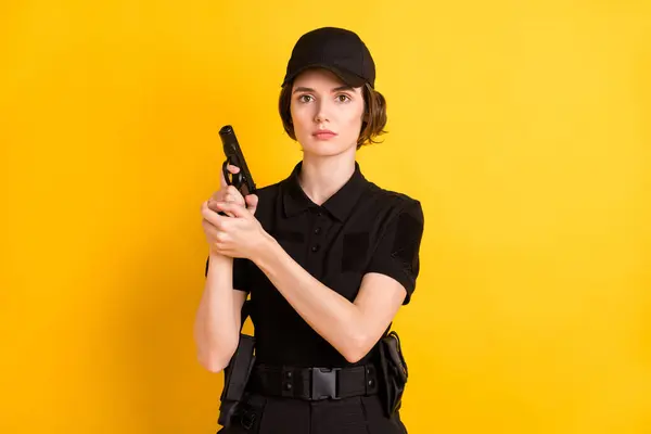 权威的女警察手持黄色背景武器手枪的照片 — 图库照片
