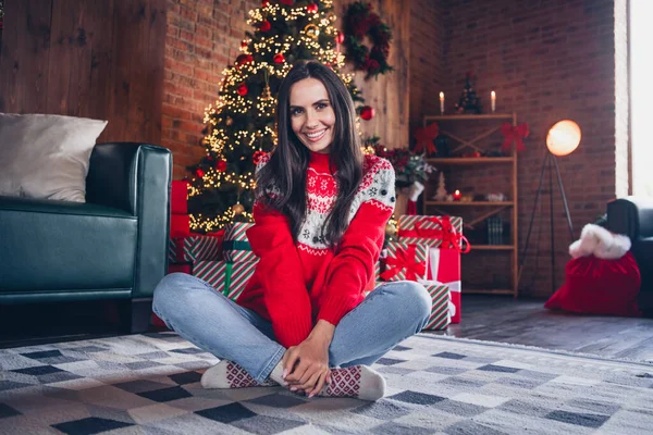 Photo of lovely good mood girl dressed red ugly sweater enjoying festal holly jolly mood at home indoors.
