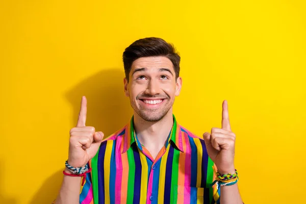 Photo of cheerful businessman in vintage shirt point fingers up look above head great idea for startup isolated on yellow color background.
