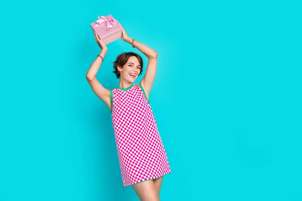 Photo of young funky lady raised hands wear plaid dress demonstrate she finally received her mail giftbox isolated on cyan color background.