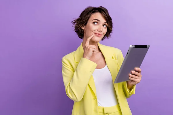 穿着黄色夹克的年轻女性 穿着紫色背景的平板电脑 带着与之隔离的想法 梦寐以求的商业伙伴的照片 — 图库照片