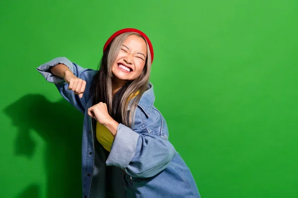 Photo of positive excited lady wear denim jacket having disco fun empty space isolated green color background.