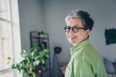 Profile side photo of aged business lady attorney company owner tooth beaming smiling wear green casual shirt modern office indoors. clipart