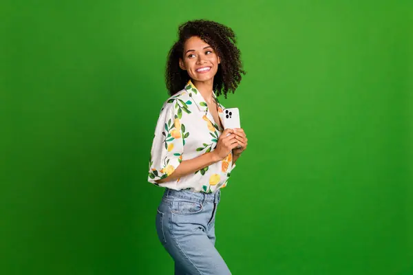 Photo of dreamy cute lady wear print shirt writing sms modern device looking empty space isolated green color background.