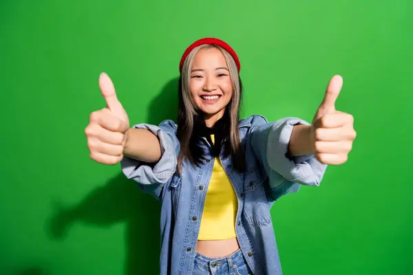 Photo of cheerful excited lady wear denim jacket showing you two thumbs up isolated green color background.