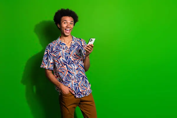Photo of funky excited man dressed print shirt chatting instagram twitter telegram facebook empty space isolated green color background.